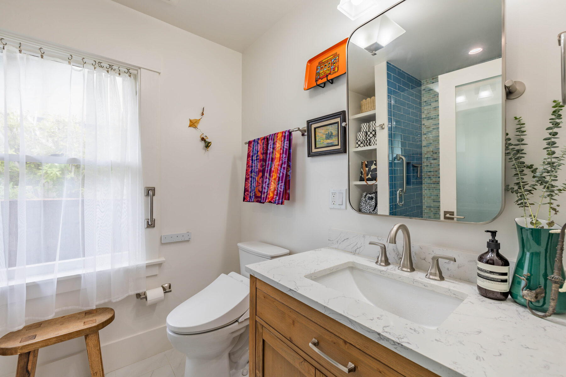 Bathroom vanity with marble counter and view to shower