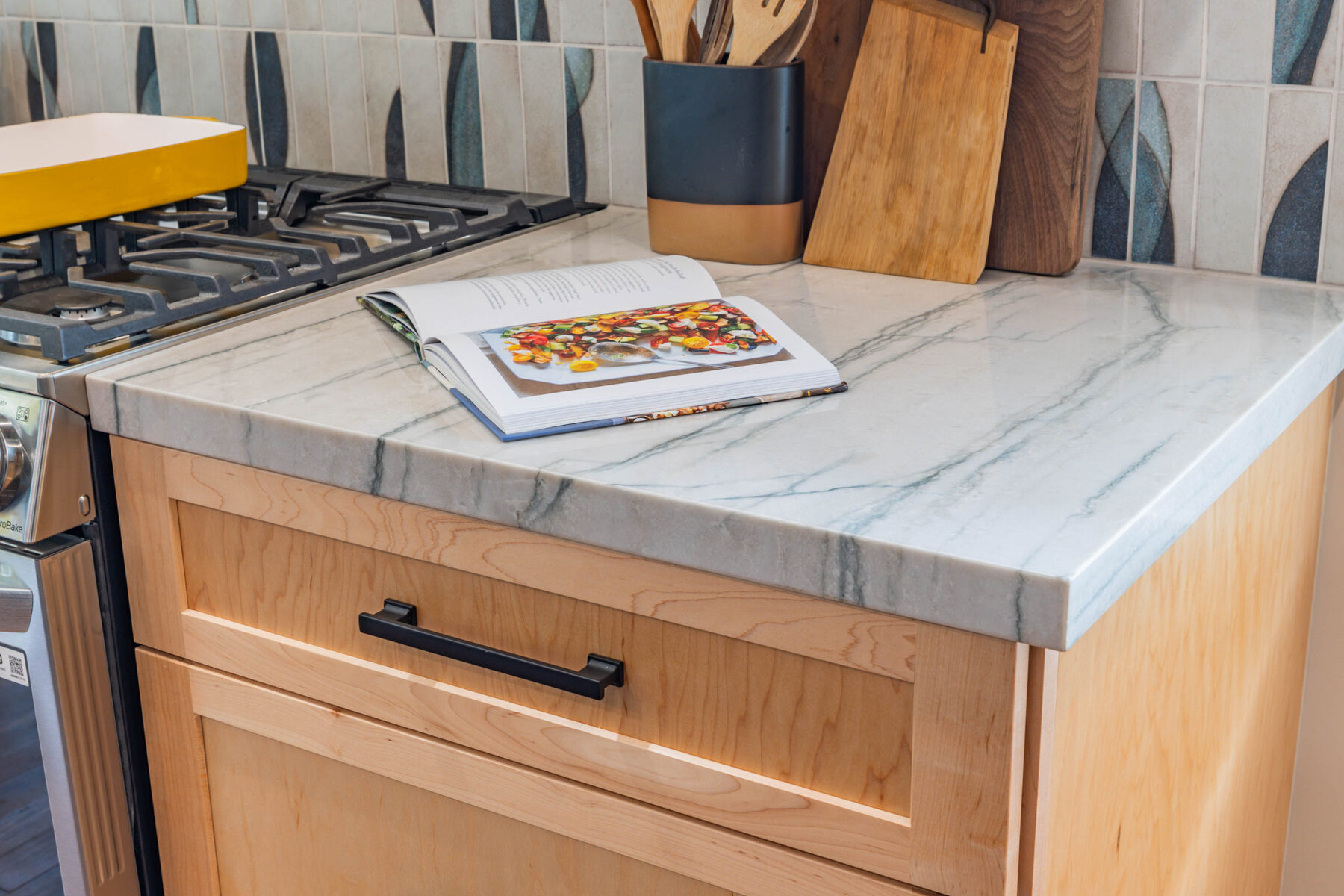 Marble counter beside stove with cookbook open