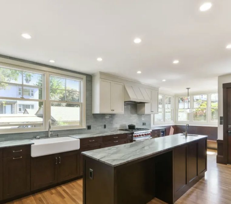 Marble-topped island with farmhouse sink and professional range