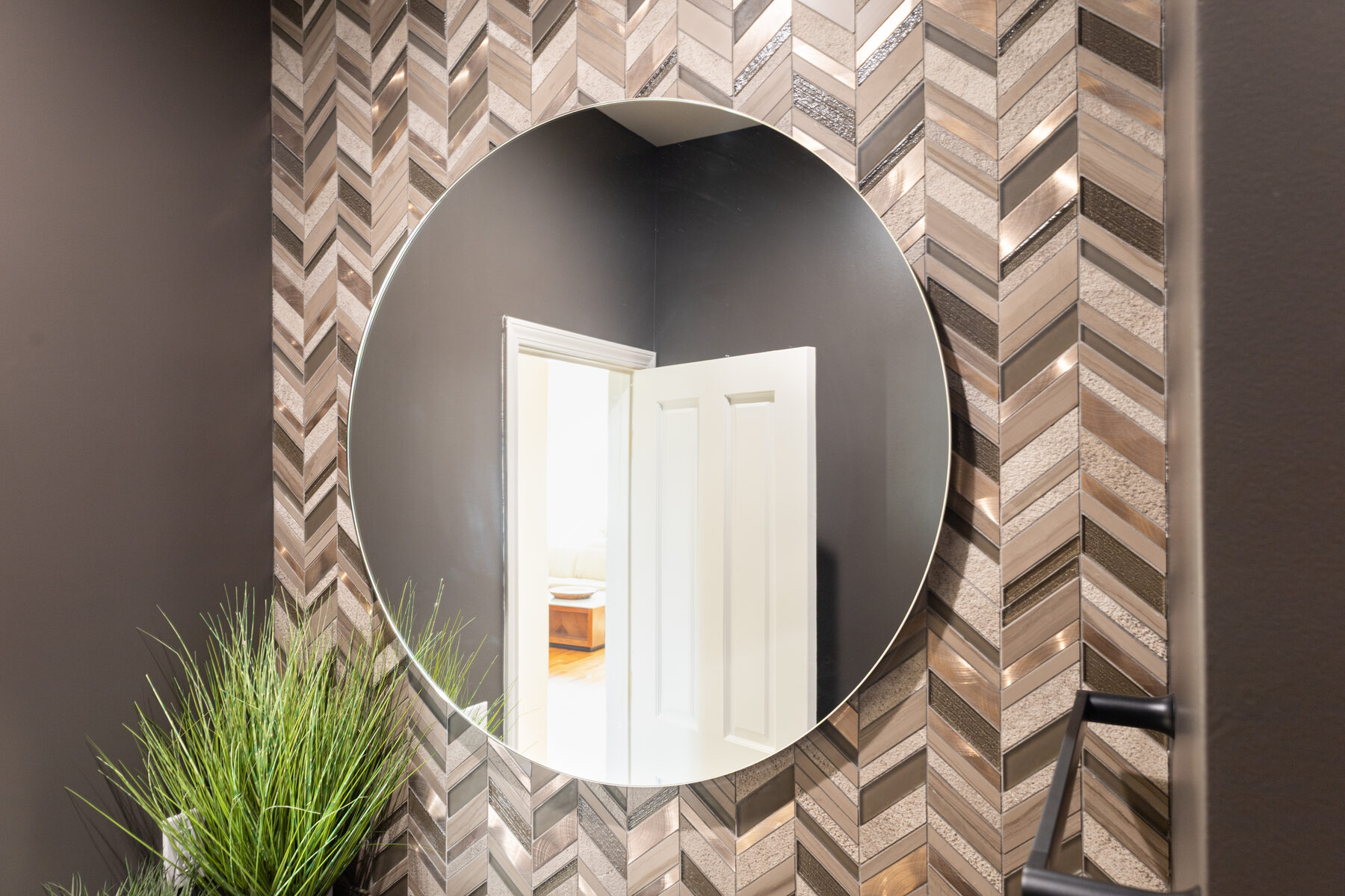 Round mirror against chevron mosaic