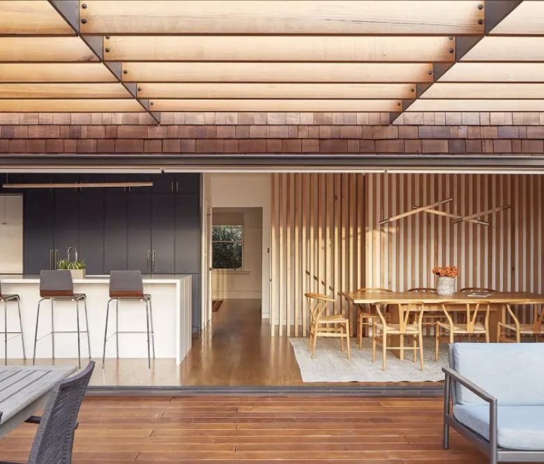 Navy kitchen with white waterfall island and cedar-slat screen