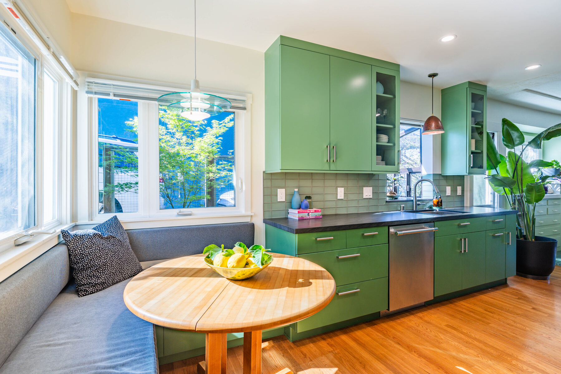 Built-in banquette with green cabinetry beyond