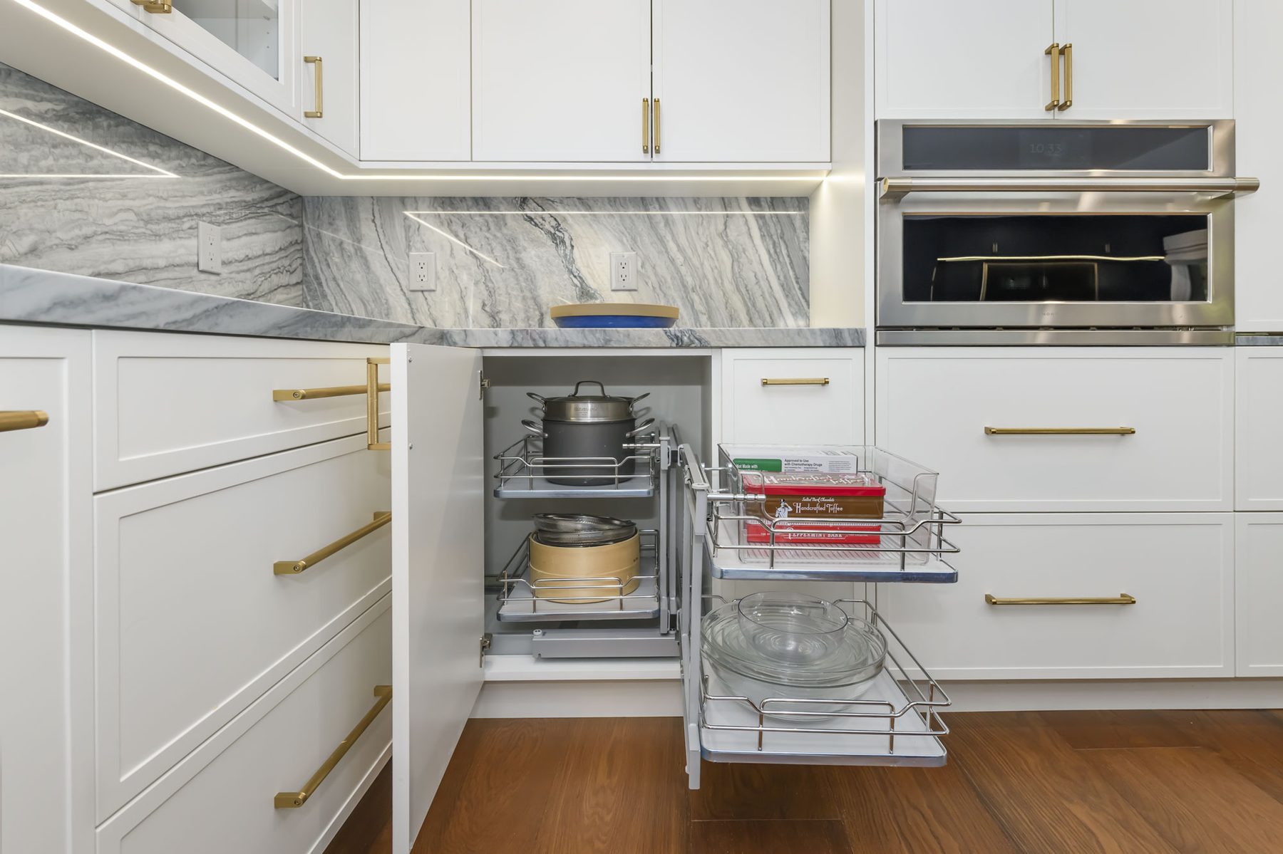 Magic Corner pull-out hardware fully extended, revealing stacked pot storage and tiered pull-out shelves