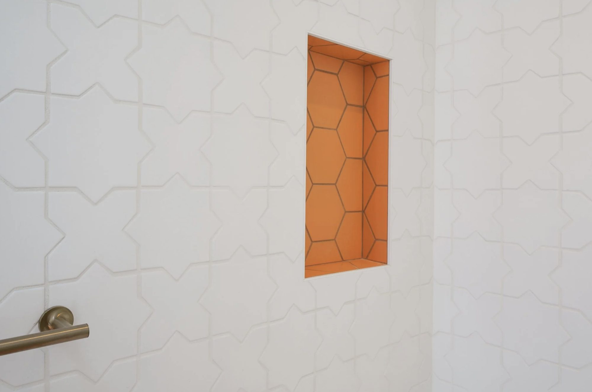 Magnolia Street shower with hand-set white star tile and terracotta hex niche