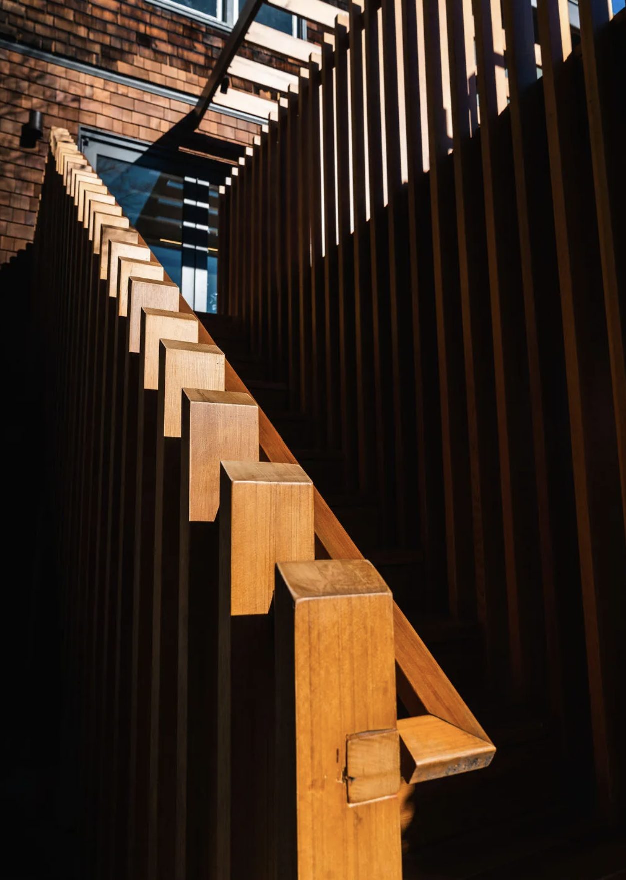 Sculptural wood stair and slatted screen detail in afternoon light