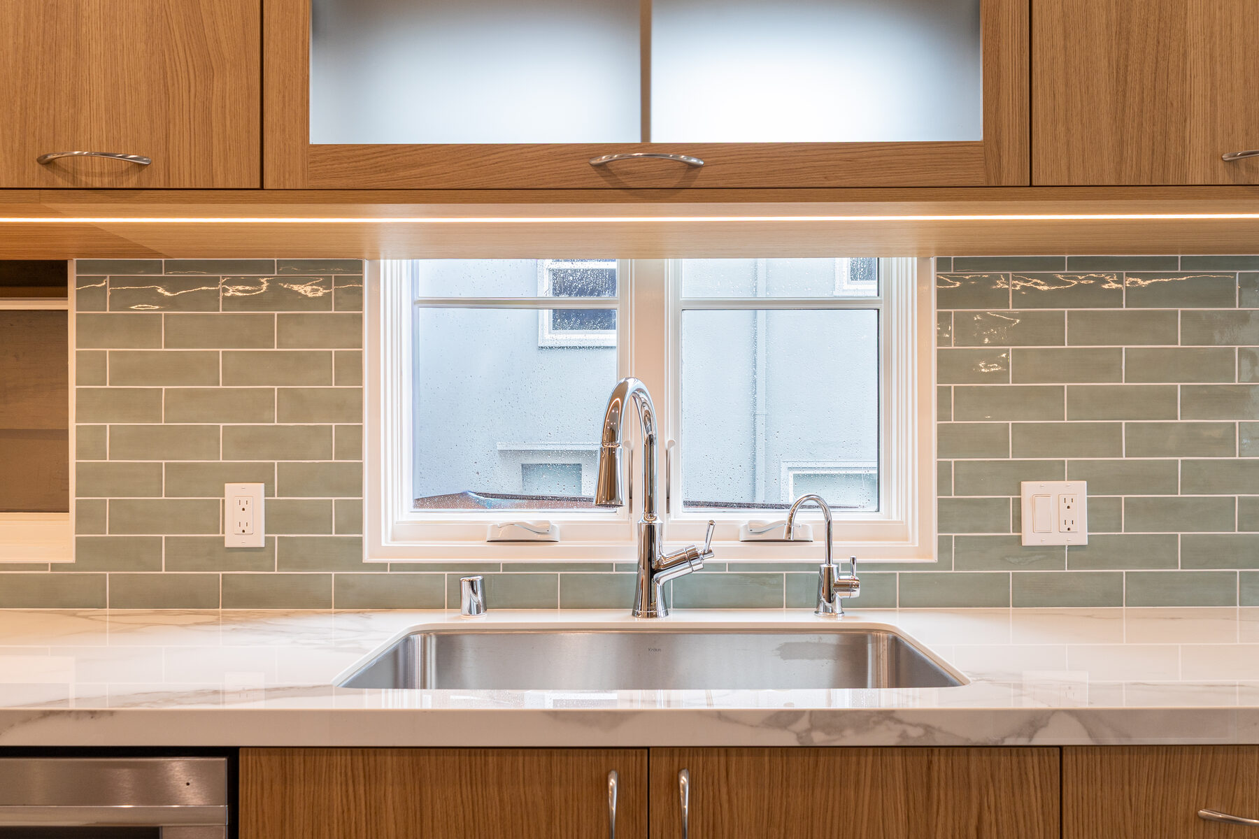 Sink detail with brass fixtures and natural stone