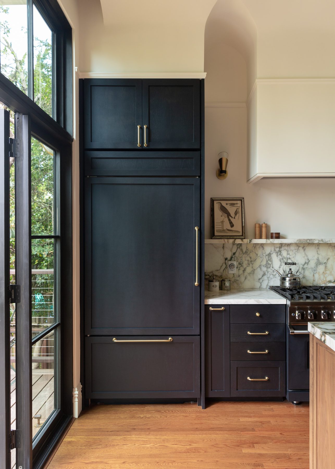 Full-height navy paneled refrigerator beside the garden door