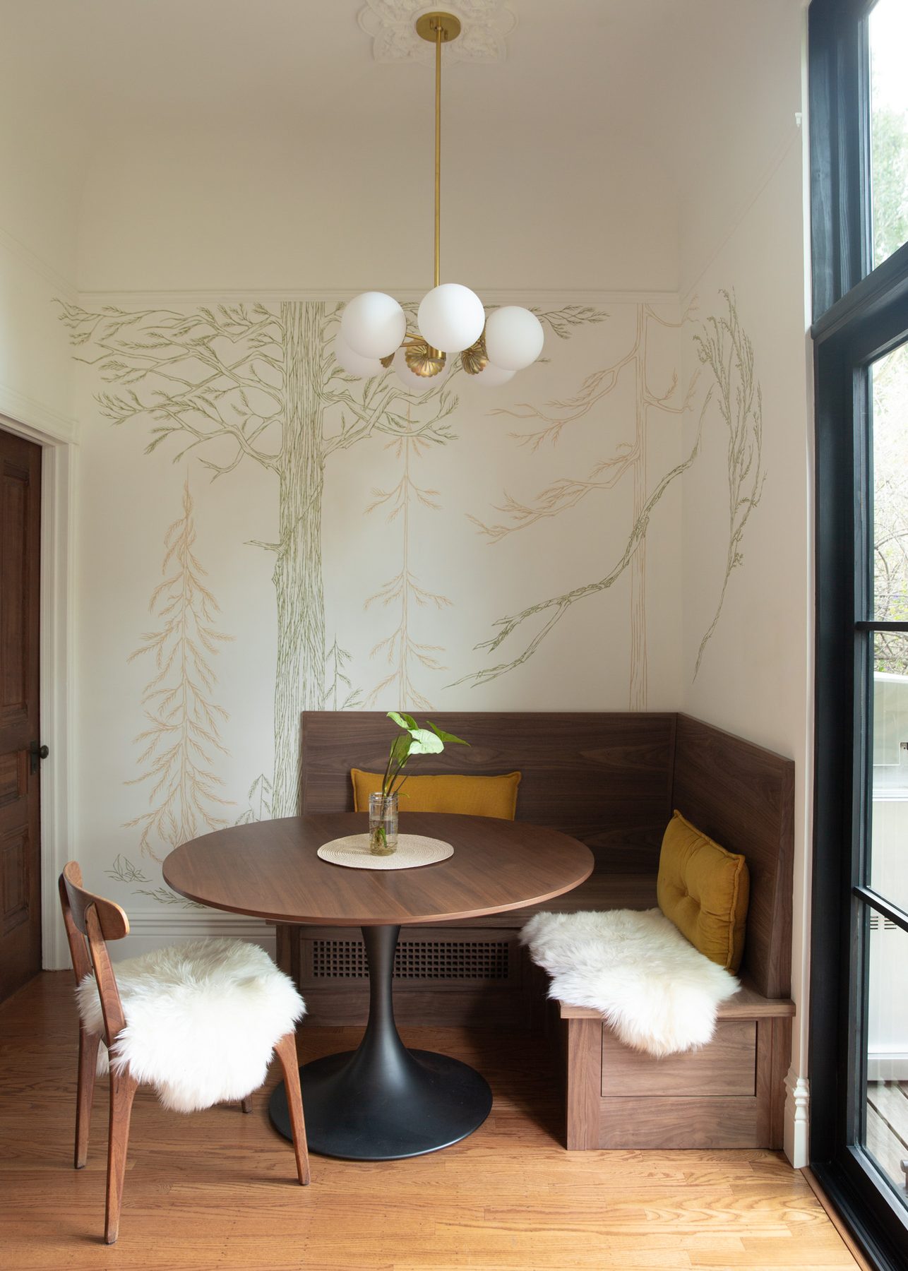 Breakfast nook with hand-painted tree mural and walnut banquette