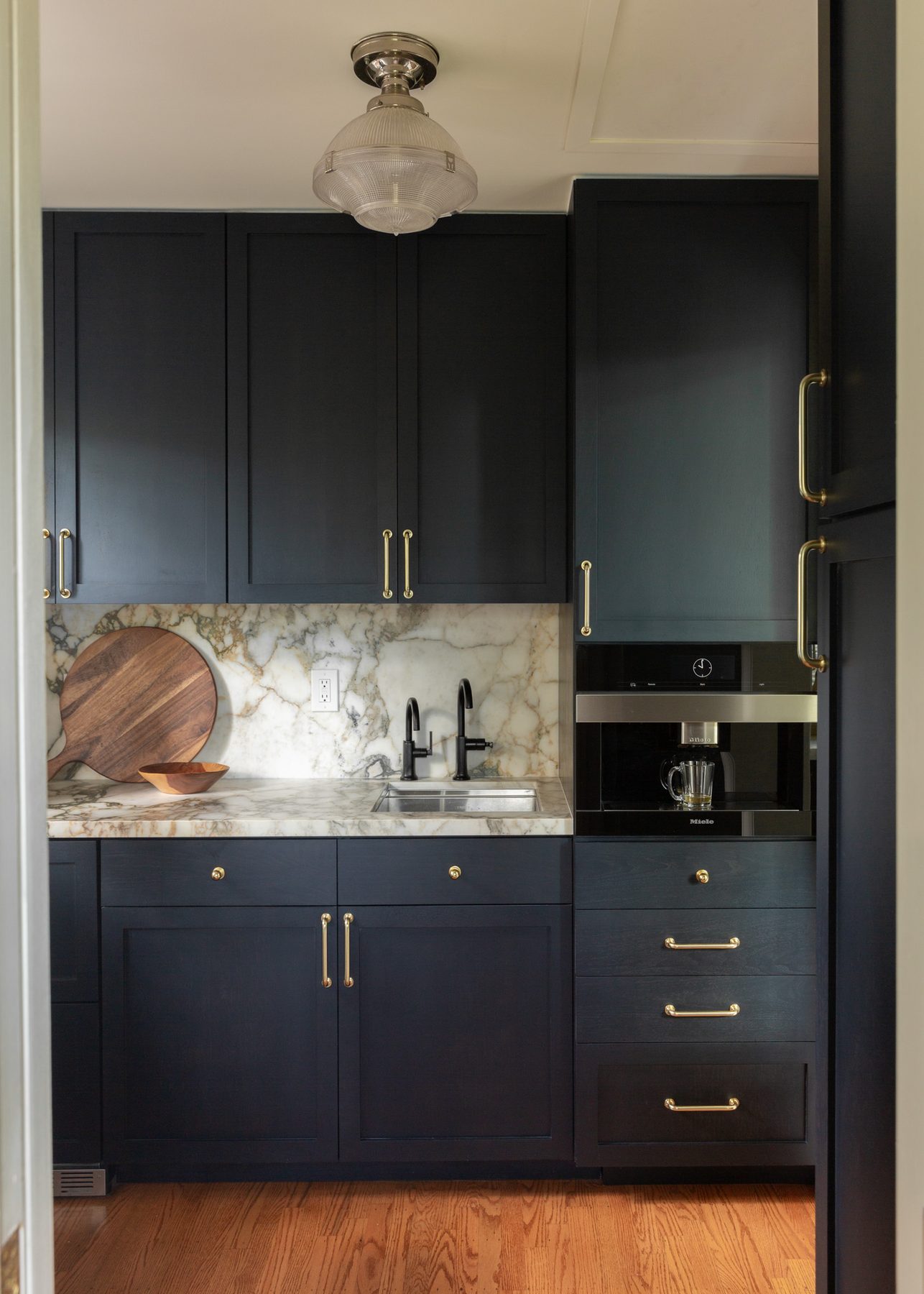 Butler's pantry with prep sink, marble counter, and built-in coffee system