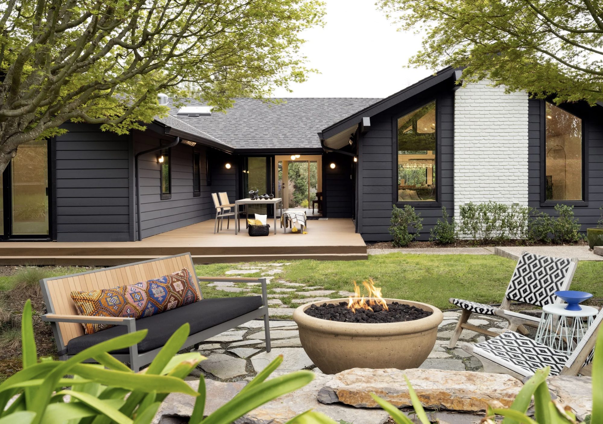Wide view of the dark mid-century exterior and garden