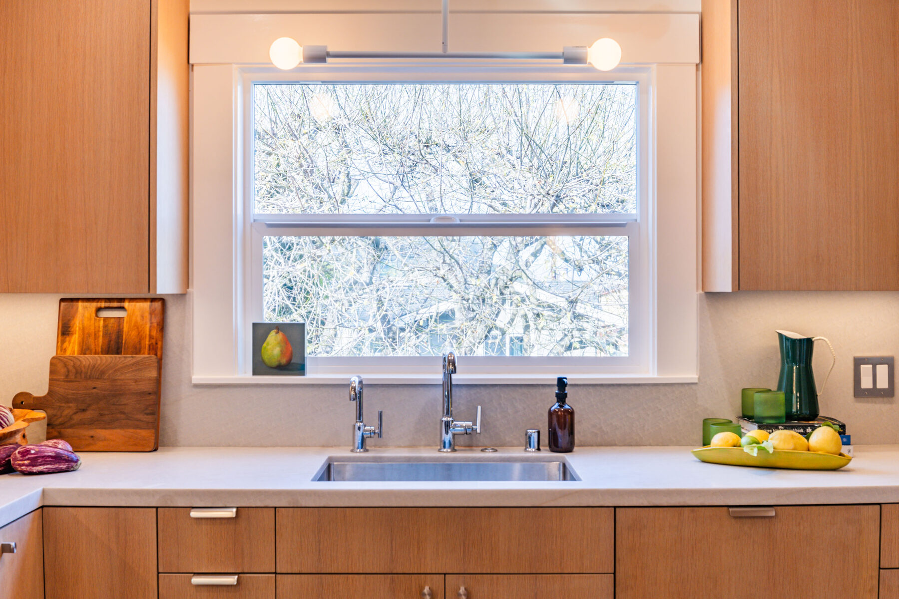 Sink wide view with chrome faucets and tree window